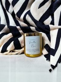 vanilla man candle on a black and white striped blanket
