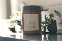 a jar with a candle sitting on top of a counter