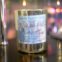 a candle with a picture of a woman sitting on top of it