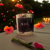 a candle sitting on a table next to flowers