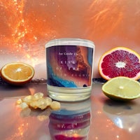 a candle with orange slices and a starry sky