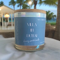 a jar of a candle with palm trees in the background