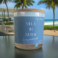 a candle sitting on a table next to the ocean