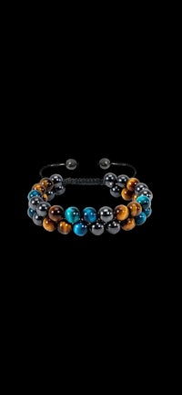 a bracelet with tiger's eye beads on a black background